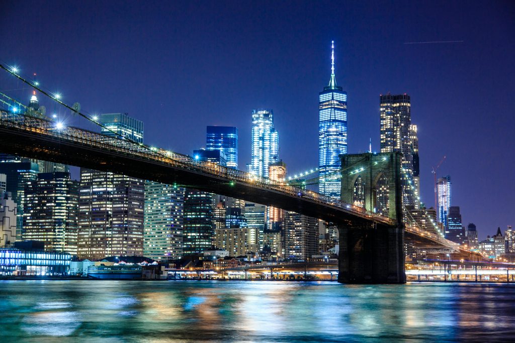 Stunning view of the Brooklyn Bridge and New York City skyline illuminated at night.